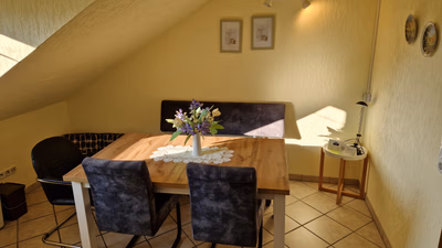 Küche mit andererm Blick auf den Esstisch mit Sitzbank und Stühle