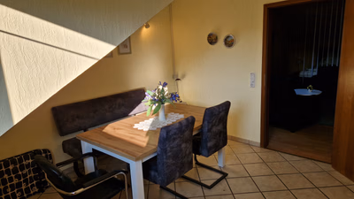 Küche mit Blick auf den Esstisch mit Sitzbank und Stühlen