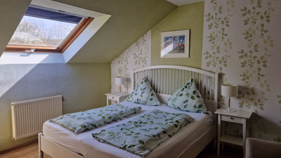 großes Schlafzimmer, modern eingerichtet, mit Blick auf das Doppelbett