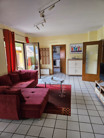 Wohnschlafzimmer: Perspektive von den Betten mit Blick auf Sofa, Gartentür, Küchentür und Tür zum Flur